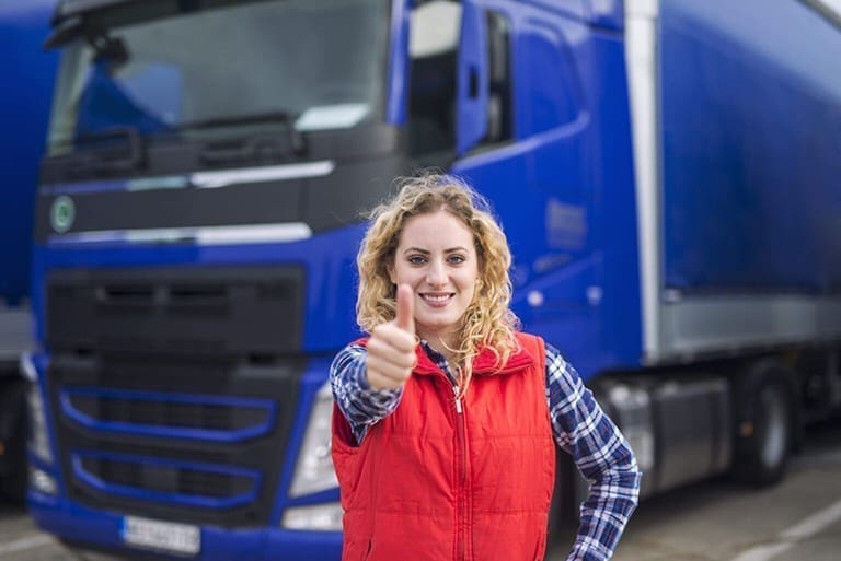 A woman standing in front of a truck showing a thumbs up, approving KNNX platform